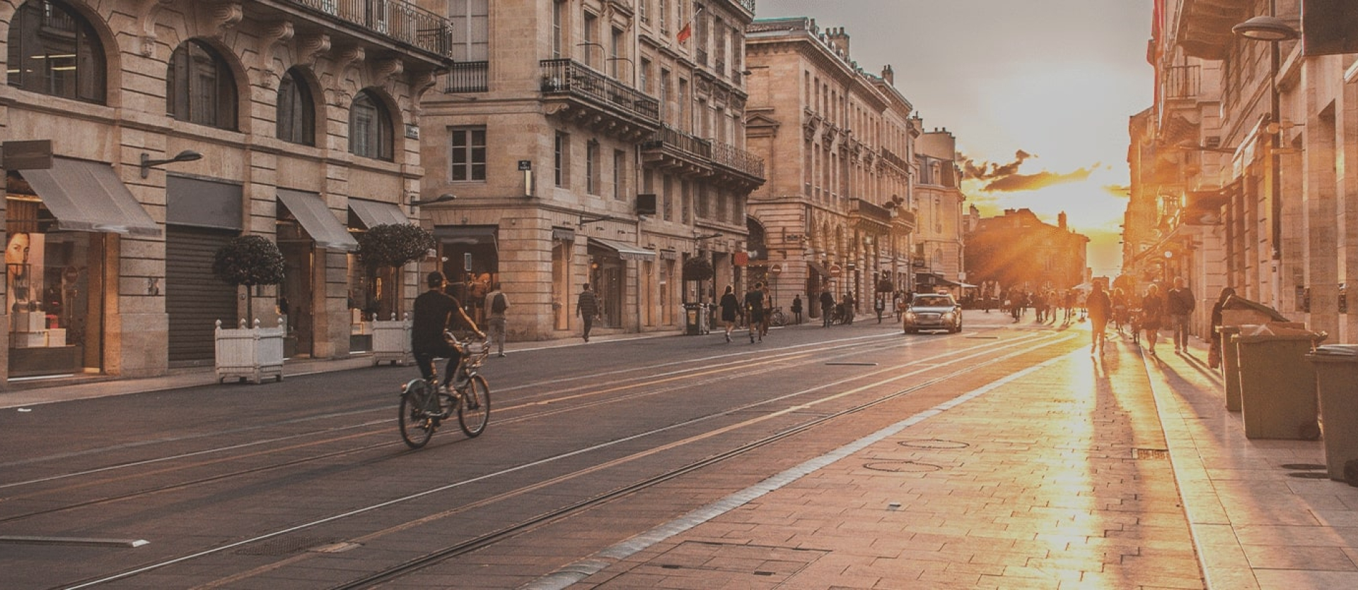 Ville dense et minérale sans végétation, sous un soleil intense, illustrant le phénomène des îlots de chaleur urbains.